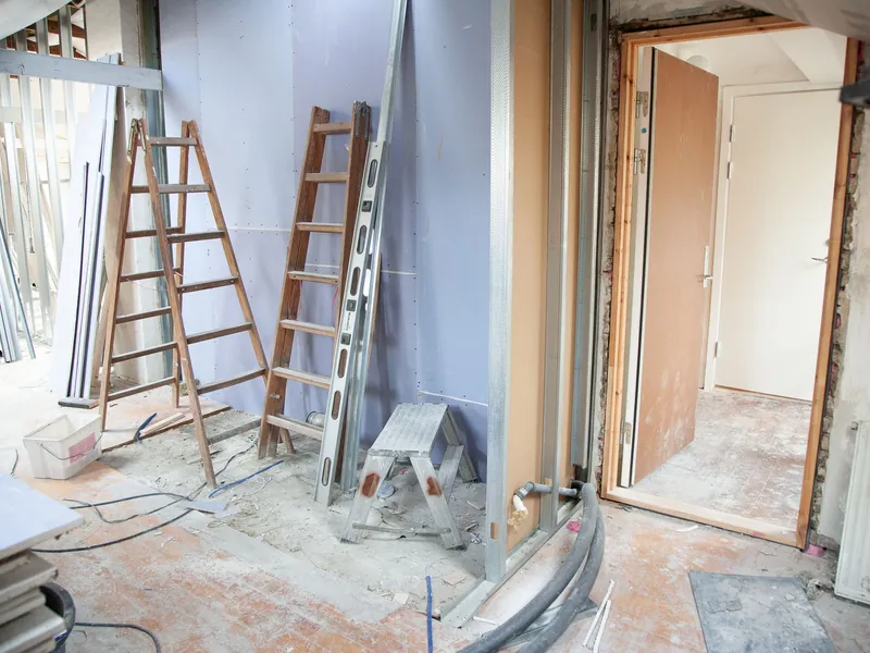 Divisão em remodelação com escadotes e materiais de obra